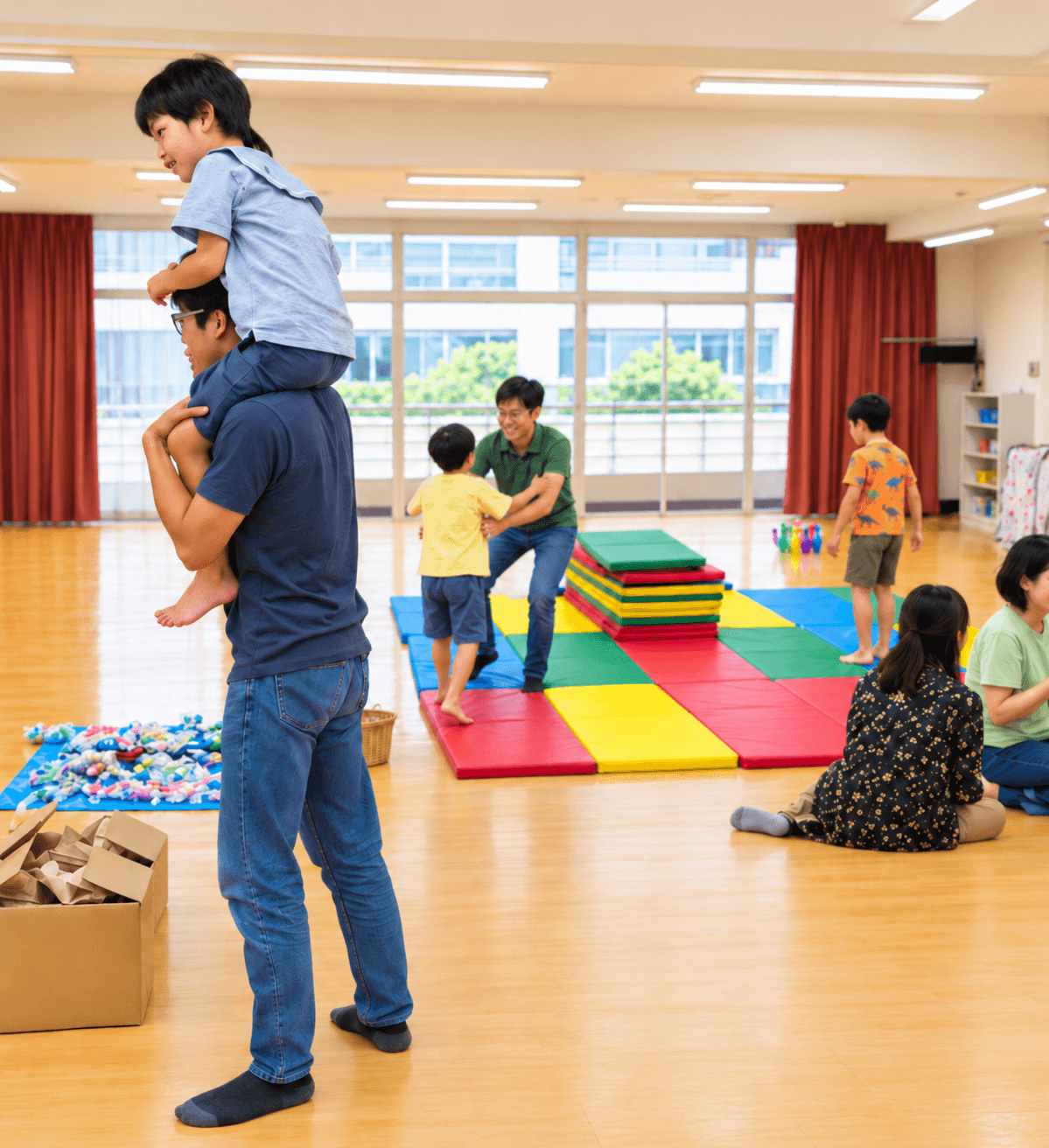 マットを敷いた室内で子どもと大人が一緒に遊ぶ様子